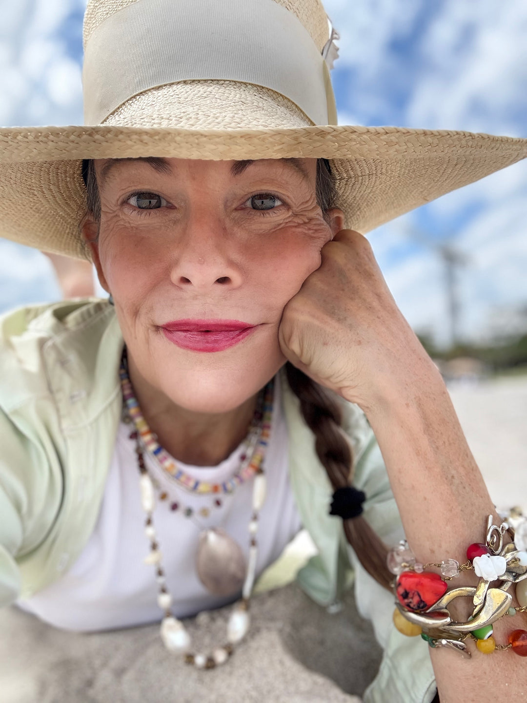 Woman wearing a wide-brimmed hat with a blurred outdoor background