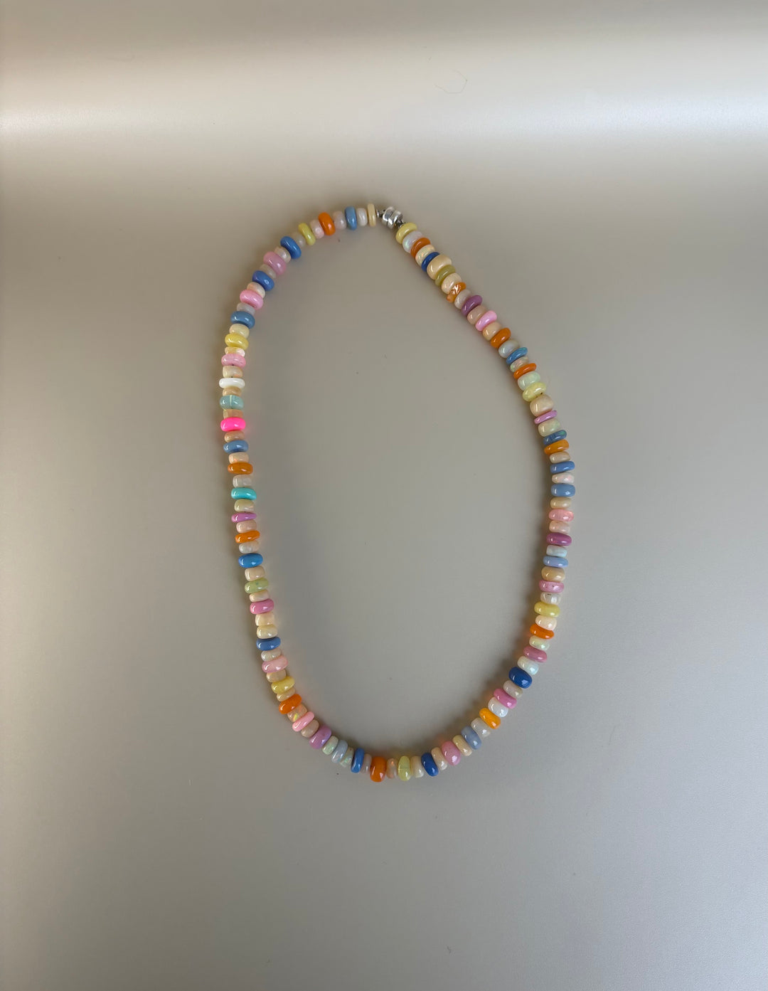 Detail of Ethiopian opal rondelle beads showing natural fire on a plain background