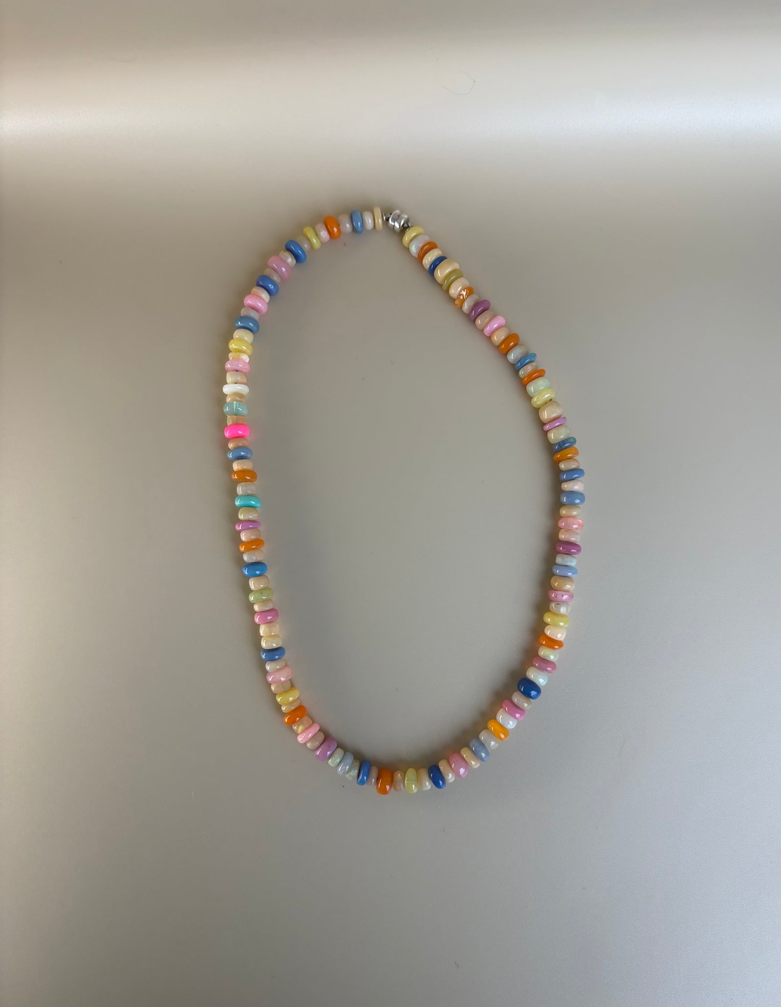 Detail of Ethiopian opal rondelle beads showing natural fire on a plain background