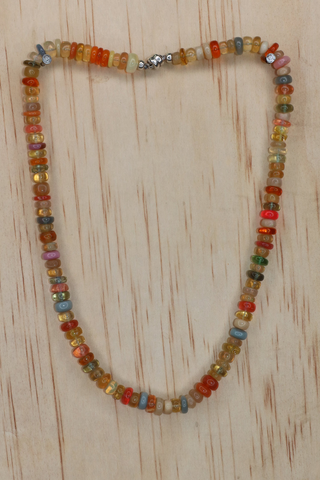 Detail of Ethiopian opal rondelle beads showing natural fire on a plain background