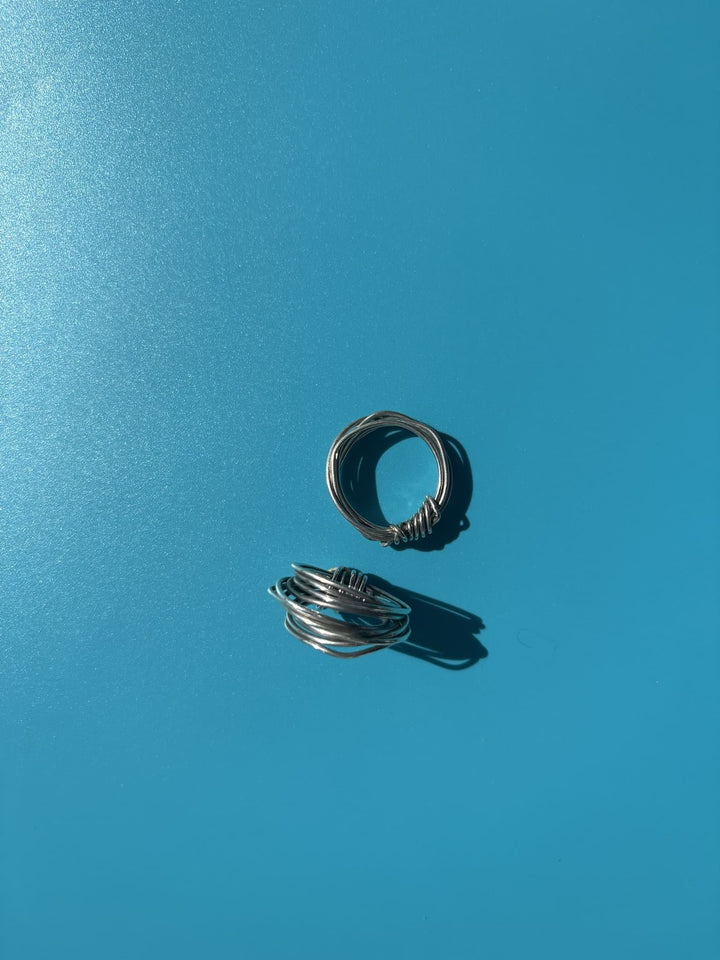 Fairmined sterling silver ring hand-wrapped from 18-gauge wire into a single knot, crafted without solder. Survivor-made ethical jewelry symbolizing resilience.