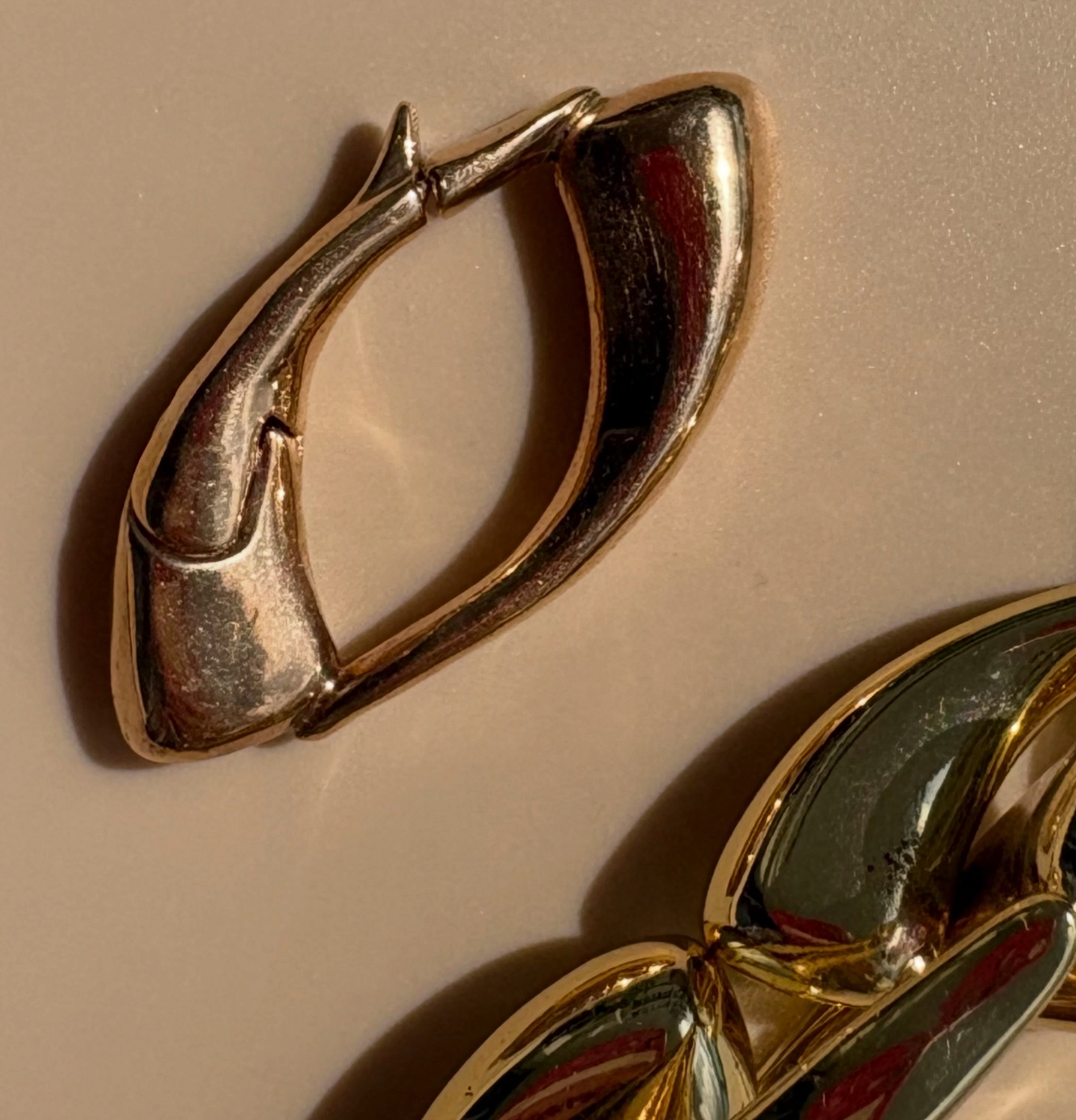 Close-up of the Signature Culebra Connector in cast bronze shown with the Limited Edition hollow brass Culebra Link Bracelet featuring a 2.5-micron gold-plated finish.