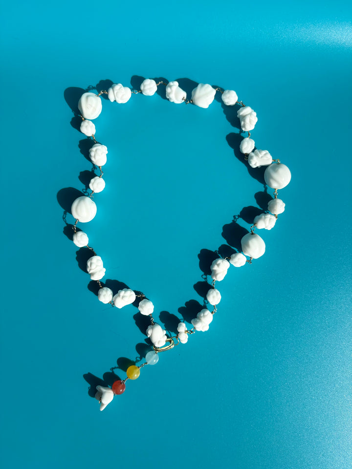 Yellow, pink, blue dyed quartz and porcelain necklace on blue background. Survivor-made jewelry by Jewelry One of a KIND.