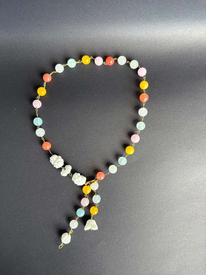  Rainbow quartz necklace on black background. Survivor-made ethical jewelry transforming grief into beauty.